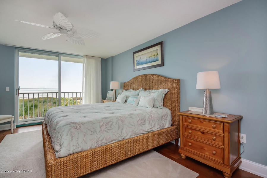 3400 Ocean Beach Boulevard, Unit 309 Cocoa Beach, FL 32931 - Photo 17 of 27 a bedroom with a bed a lamp and a large window
