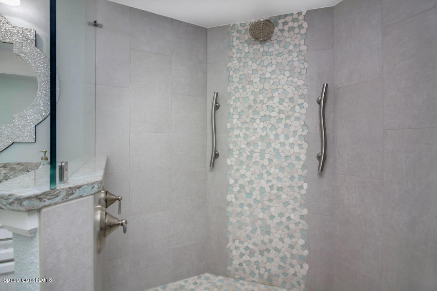 3400 Ocean Beach Boulevard, Unit 309 Cocoa Beach, FL 32931 - Photo 19 of 27 a bathroom with a shower curtain