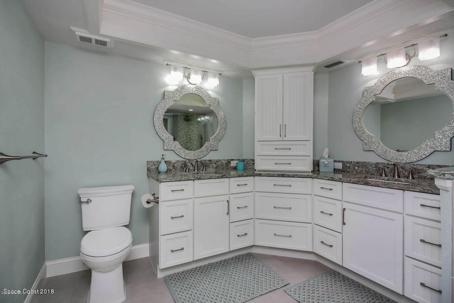 3400 Ocean Beach Boulevard, Unit 309 Cocoa Beach, FL 32931 - Photo 20 of 27 a bathroom with a toilet a sink and mirror