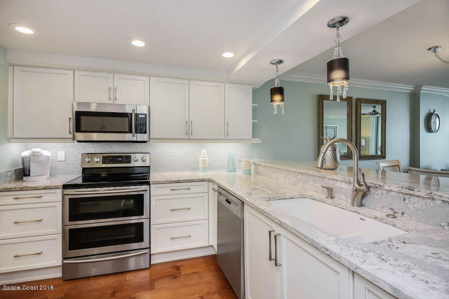 3400 Ocean Beach Boulevard, Unit 309 Cocoa Beach, FL 32931 - Photo 7 of 27 a kitchen with granite countertop a stove and a sink