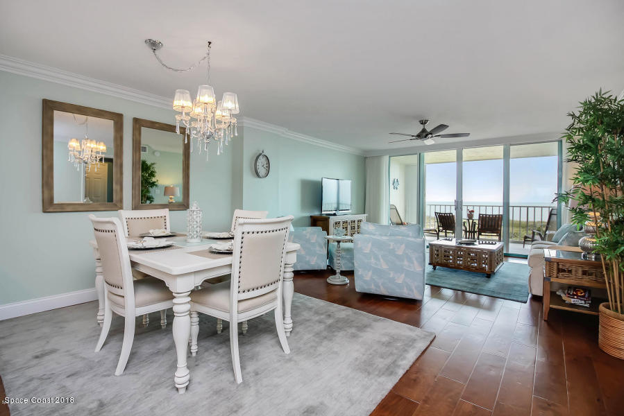 3400 Ocean Beach Boulevard, Unit 309 Cocoa Beach, FL 32931 - Photo 10 of 27 a living room with furniture and a chandelier