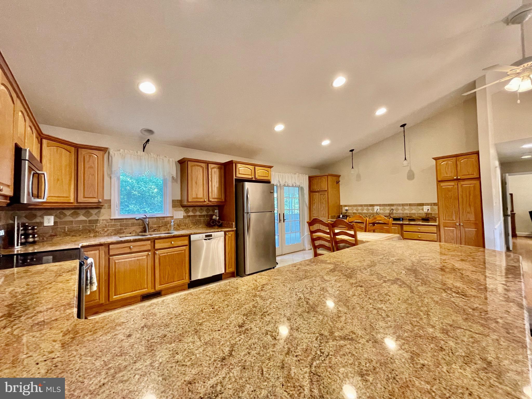 1270 Calvert Beach Road St. Leonard, MD 20685 - Photo 6 of 31 a large kitchen with kitchen island a large counter top stainless steel appliances and cabinets