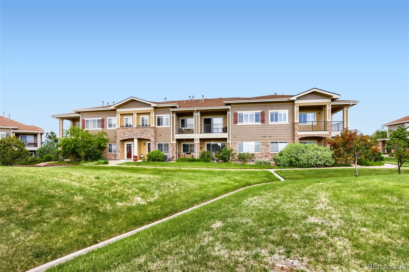 6232 Kilmer Loop, Unit 203 Golden, CO 80403 - Photo 29 of 33 a front view of a house with a yard and trees
