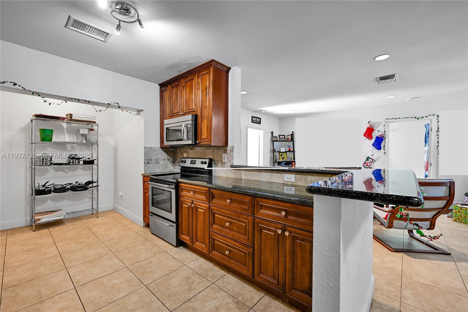 6500 Northwest 27th Street Sunrise, FL 33313 - Photo 5 of 16 a kitchen with stainless steel appliances granite countertop a sink and cabinets