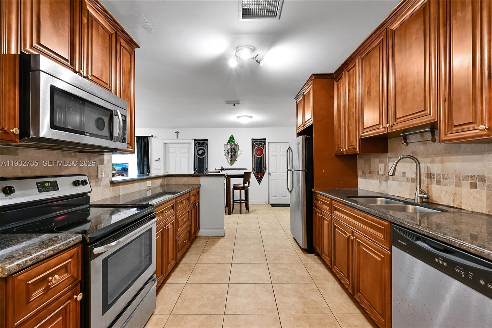 6500 Northwest 27th Street Sunrise, FL 33313 - Photo 6 of 16 a kitchen with stainless steel appliances granite countertop a stove top oven a sink and dishwasher