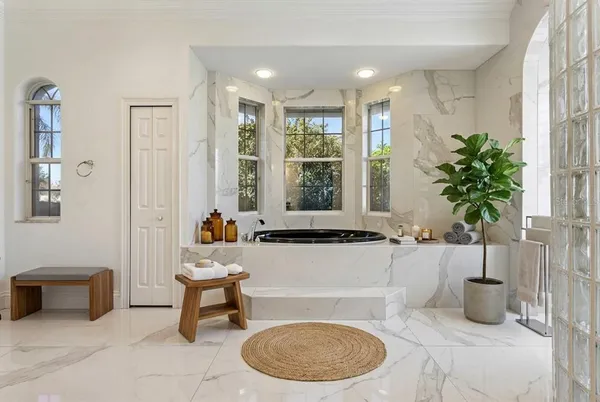 a spacious bathroom with a granite countertop sink mirror and a bathtub
