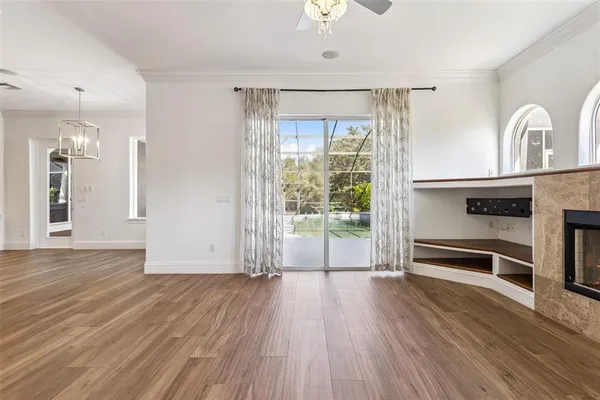 an empty room with windows and ceiling fan