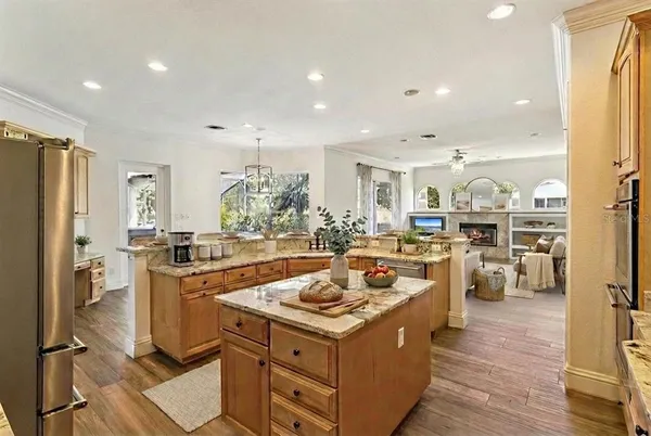 an empty room with a chandelier fan and wooden floor