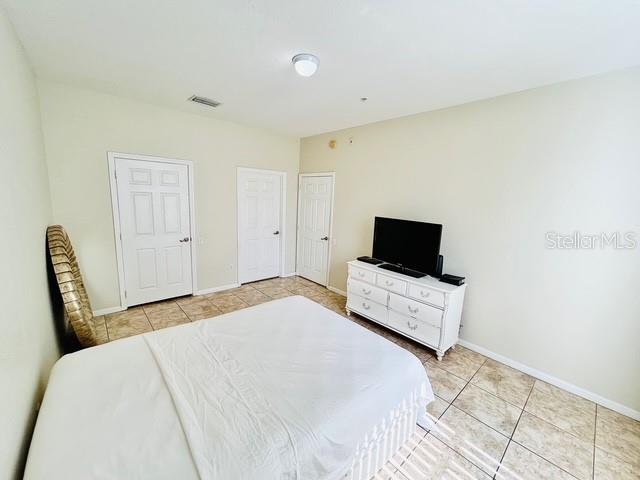 13500 Turtle Marsh Loop, Unit 825 Orlando, FL 32837 - Photo 11 of 19 a bedroom with a bed and a flat screen tv