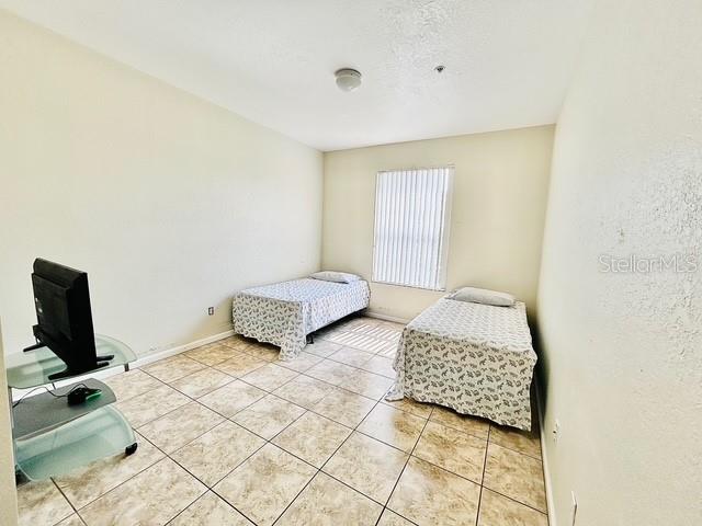 13500 Turtle Marsh Loop, Unit 825 Orlando, FL 32837 - Photo 14 of 19 a bedroom with a bed and a flat screen tv