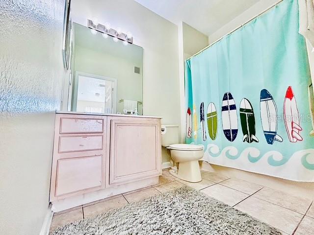 13500 Turtle Marsh Loop, Unit 825 Orlando, FL 32837 - Photo 15 of 19 a bathroom with a toilet and a shower curtain