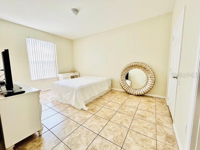 13500 Turtle Marsh Loop, Unit 825 Orlando, FL 32837 - Photo 10 of 19 a bedroom with a bed and a flat tv screen on dresser