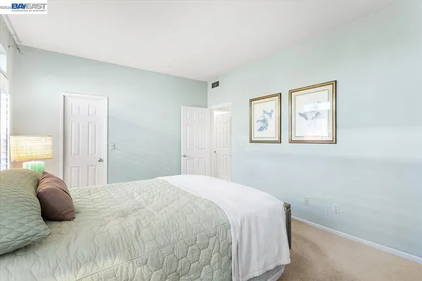 a bedroom with a bed and a painting on the wall