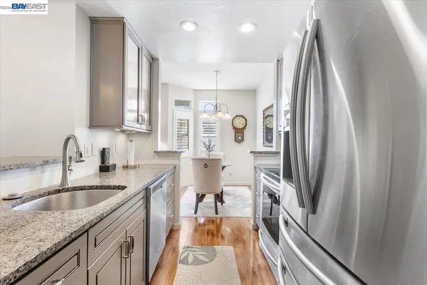 a kitchen with kitchen island granite countertop a sink stove and refrigerator