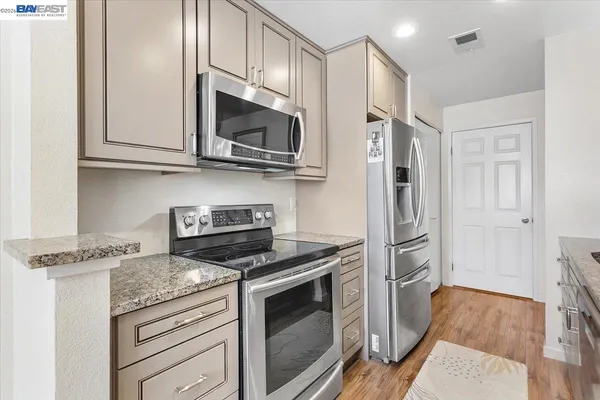 a kitchen with stainless steel appliances granite countertop a stove microwave and refrigerator