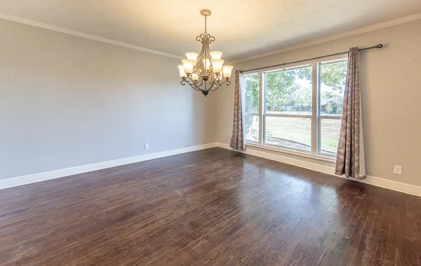 an empty room with windows and ceiling fan