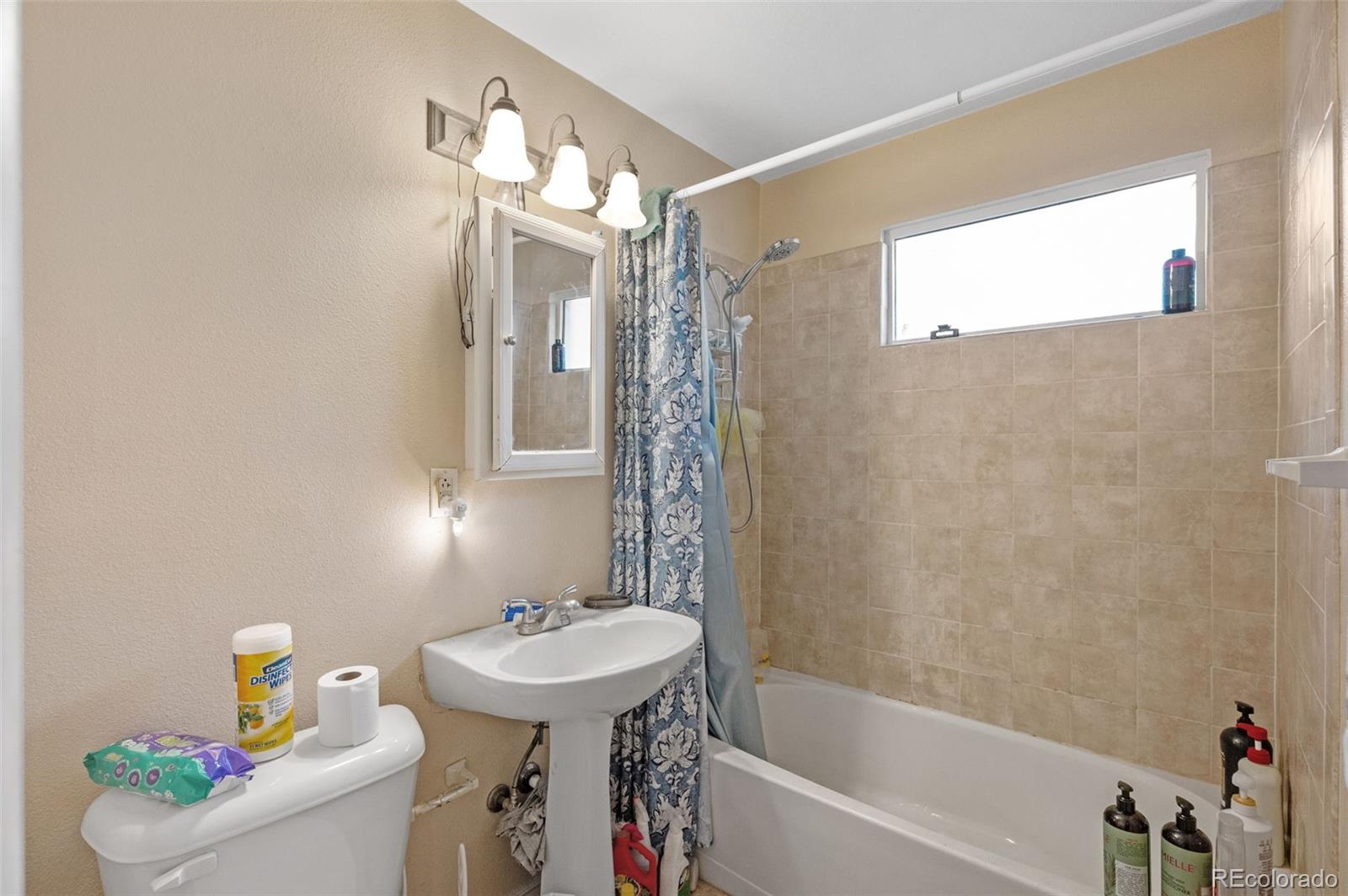 4956 Umatilla Street Denver, CO 80221 - Photo 13 of 33 a bathroom with a sink a toilet and shower