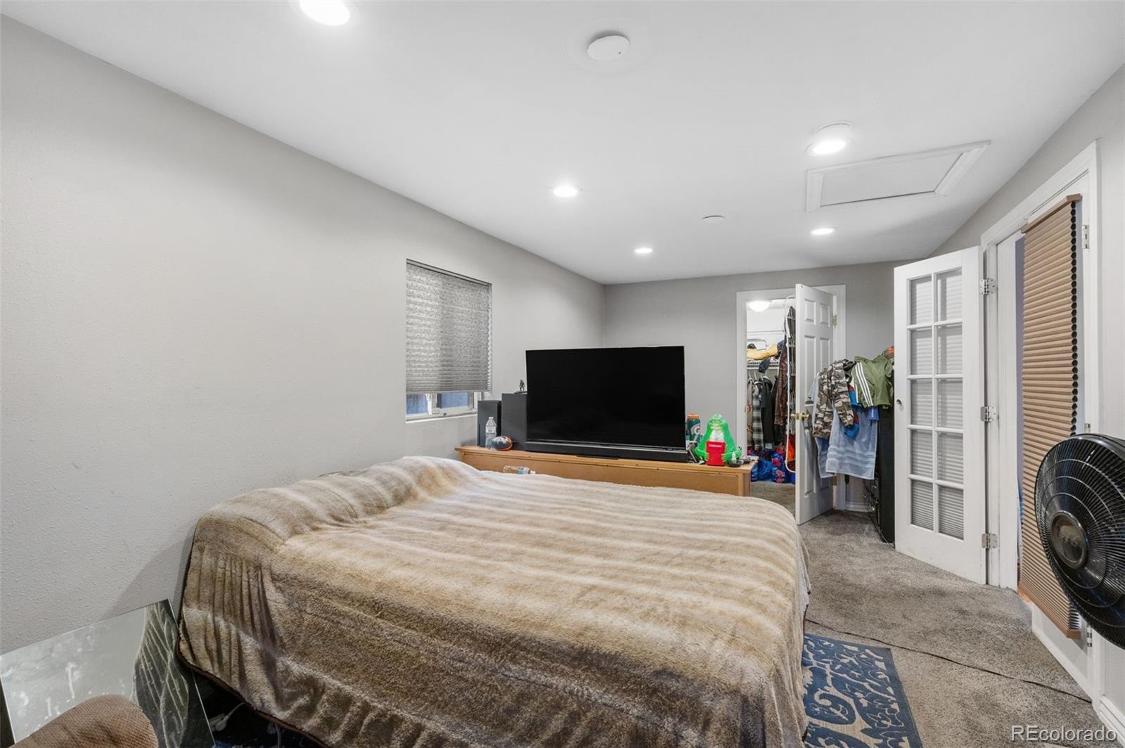 4956 Umatilla Street Denver, CO 80221 - Photo 16 of 33 a bedroom with a bed and a flat screen tv