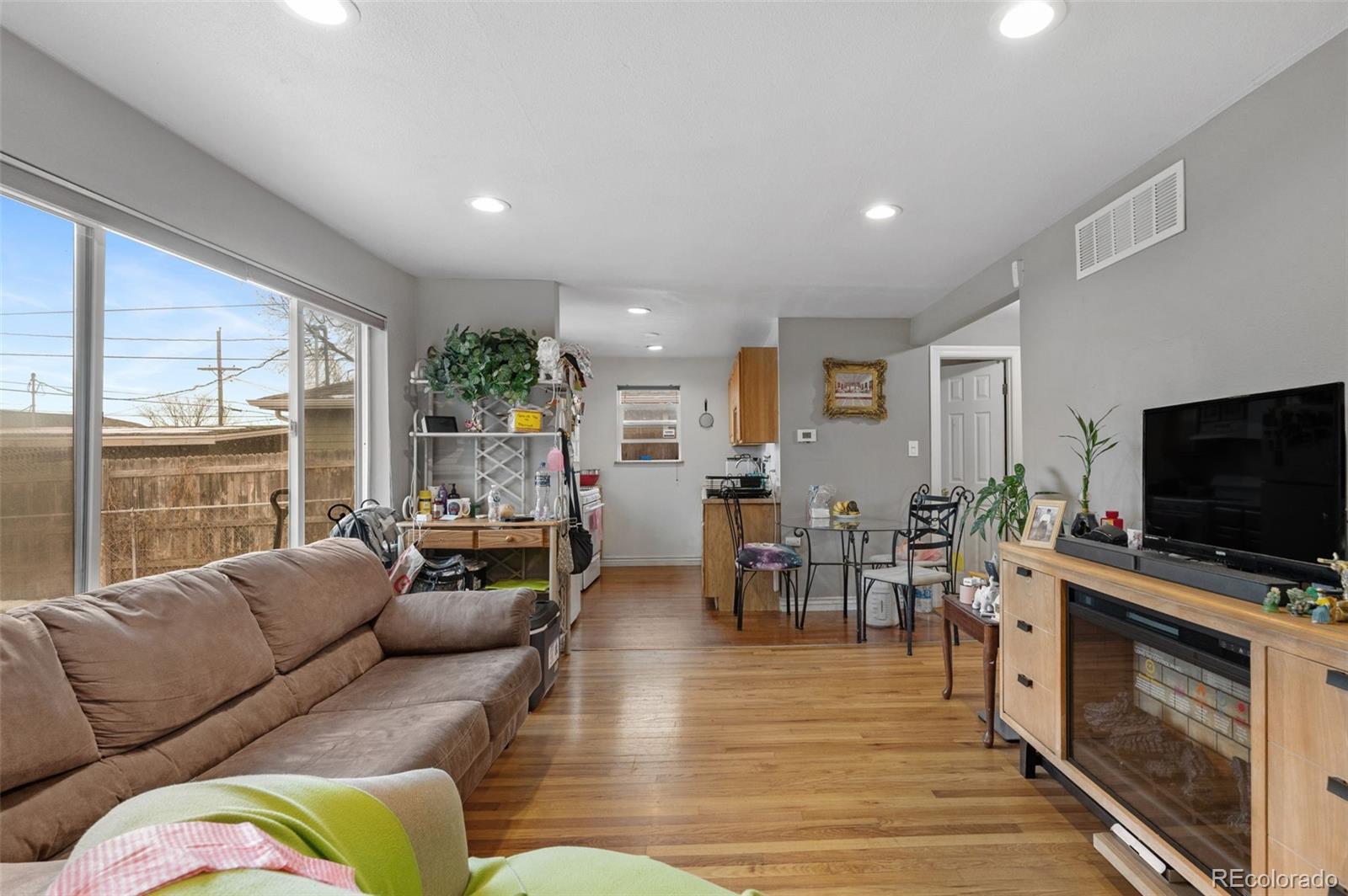 4956 Umatilla Street Denver, CO 80221 - Photo 7 of 33 a living room with furniture flat screen tv and a large window