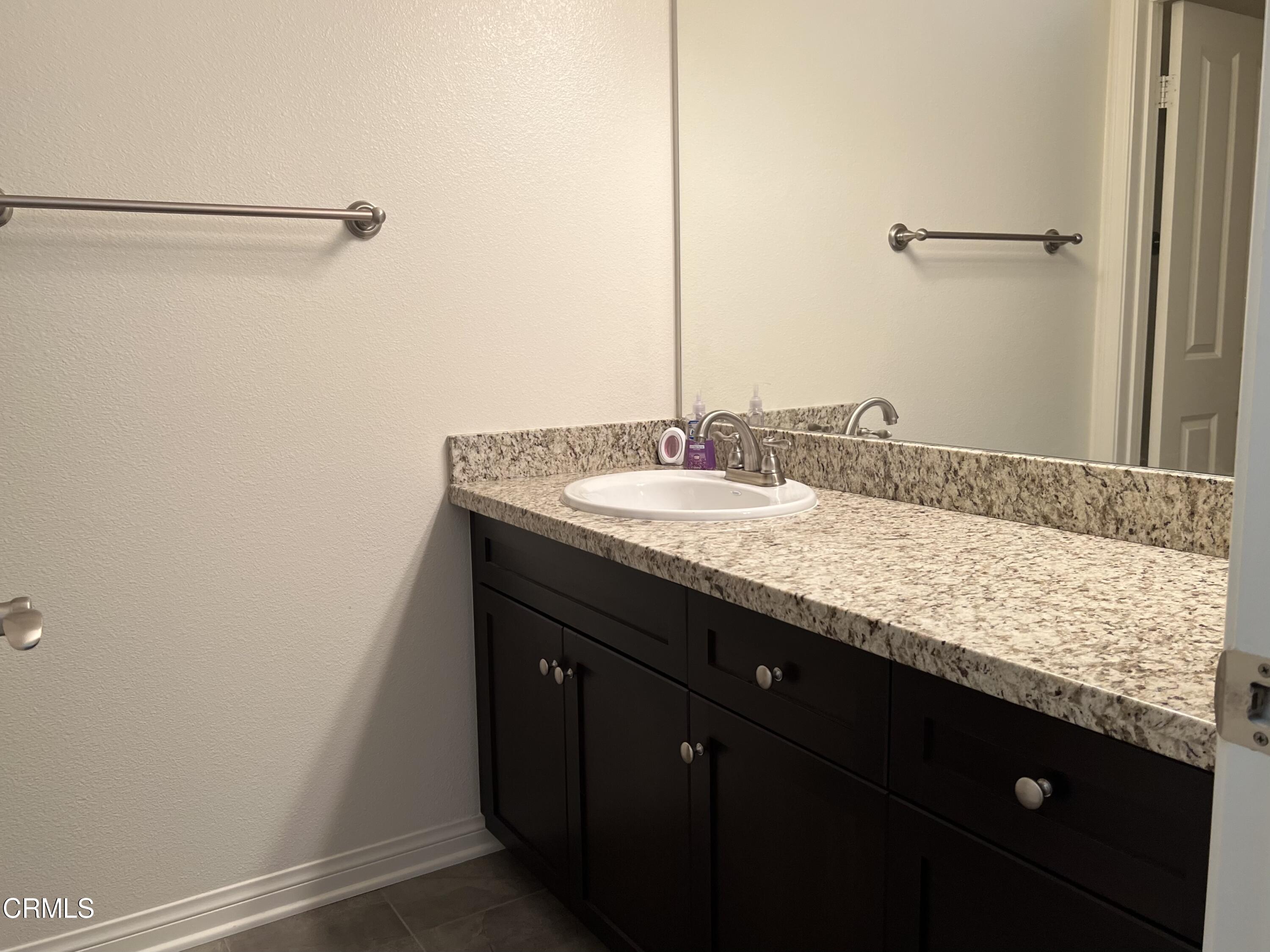 668 Owens River Drive Oxnard, CA 93036 - Photo 11 of 16 a bathroom with a granite countertop sink and a mirror