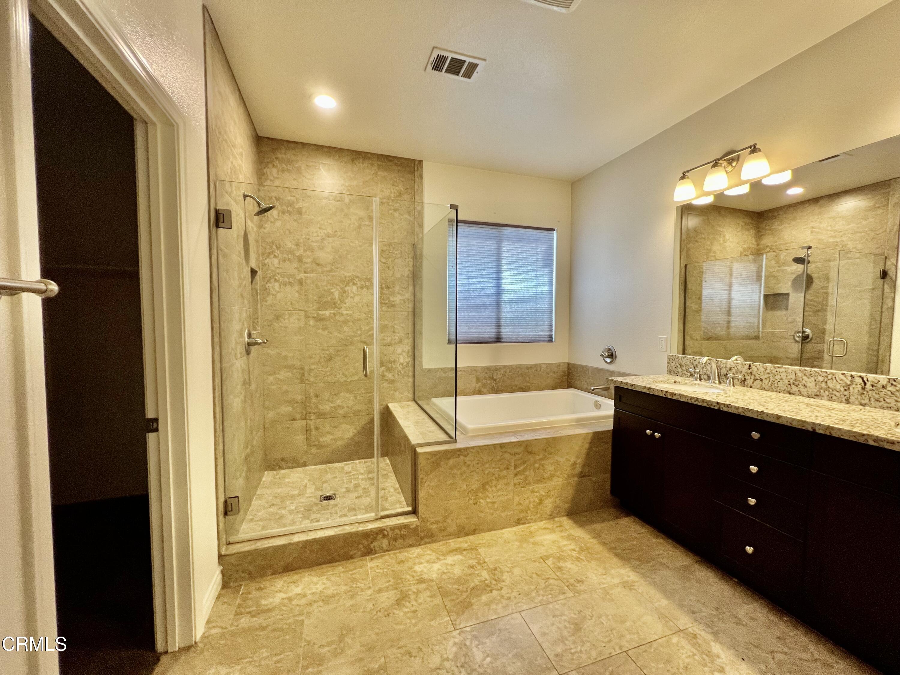 668 Owens River Drive Oxnard, CA 93036 - Photo 15 of 16 a bathroom with a granite countertop tub sink shower and mirror
