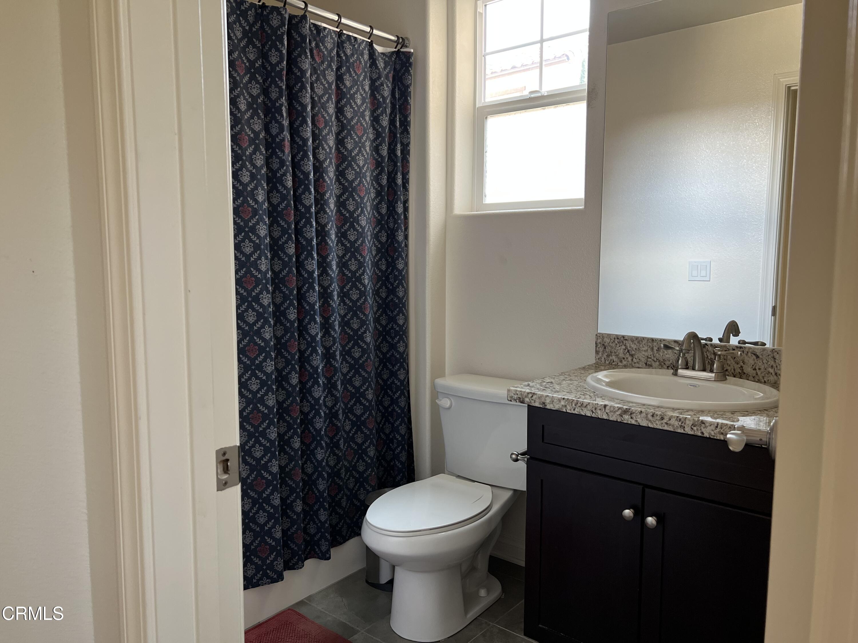 668 Owens River Drive Oxnard, CA 93036 - Photo 7 of 16 a bathroom with a granite countertop toilet a sink and a window