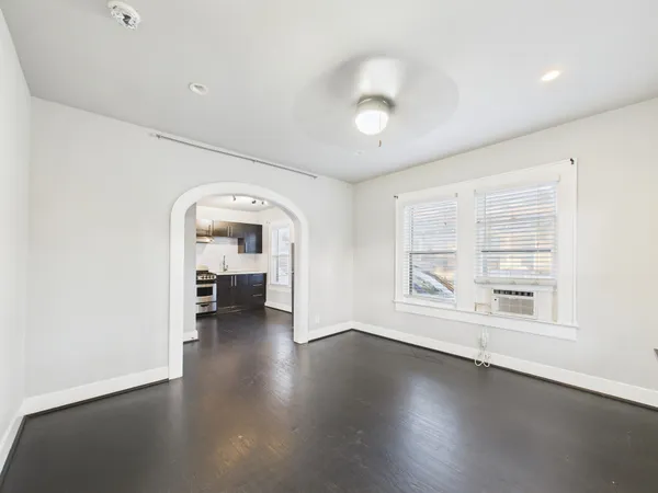 an empty room with wooden floor and a large window