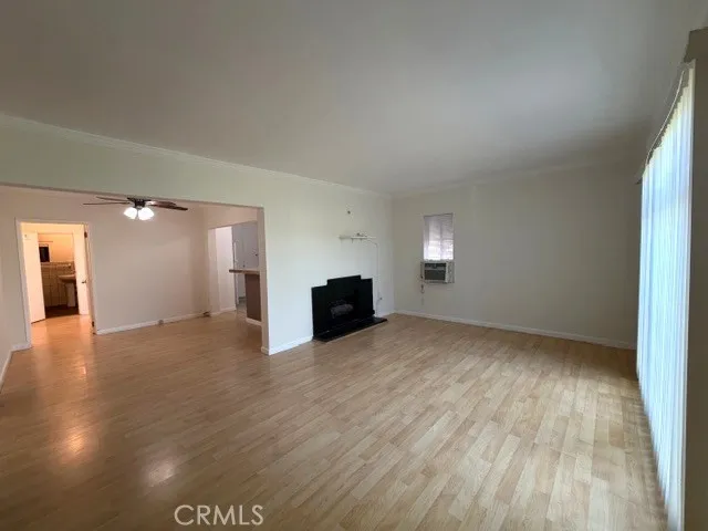 a view of empty room with wooden floor and fireplace