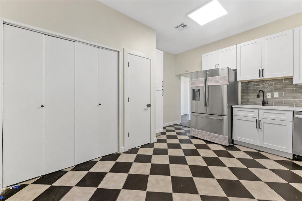 610 West 35th Street, Unit B Austin, TX 78705 - Photo 6 of 23 Kitchen featuring stainless steel appliances, white cabinetry, light flooring, tasteful backsplash, and light stone countertops