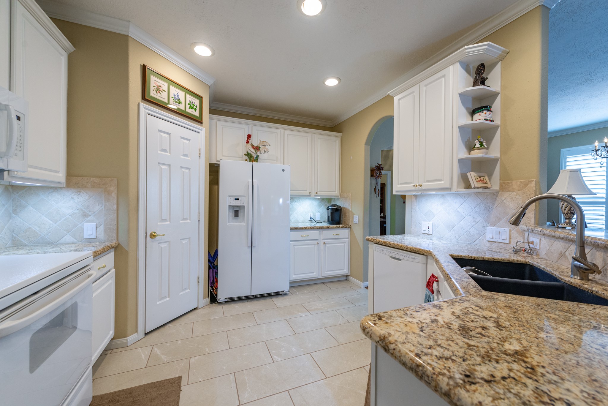 5230 Sandyfields Lane Katy, TX 77494 - Photo 13 of 24 White cabinetry with ample storage, built-in microwave, electric range, and pantry access.