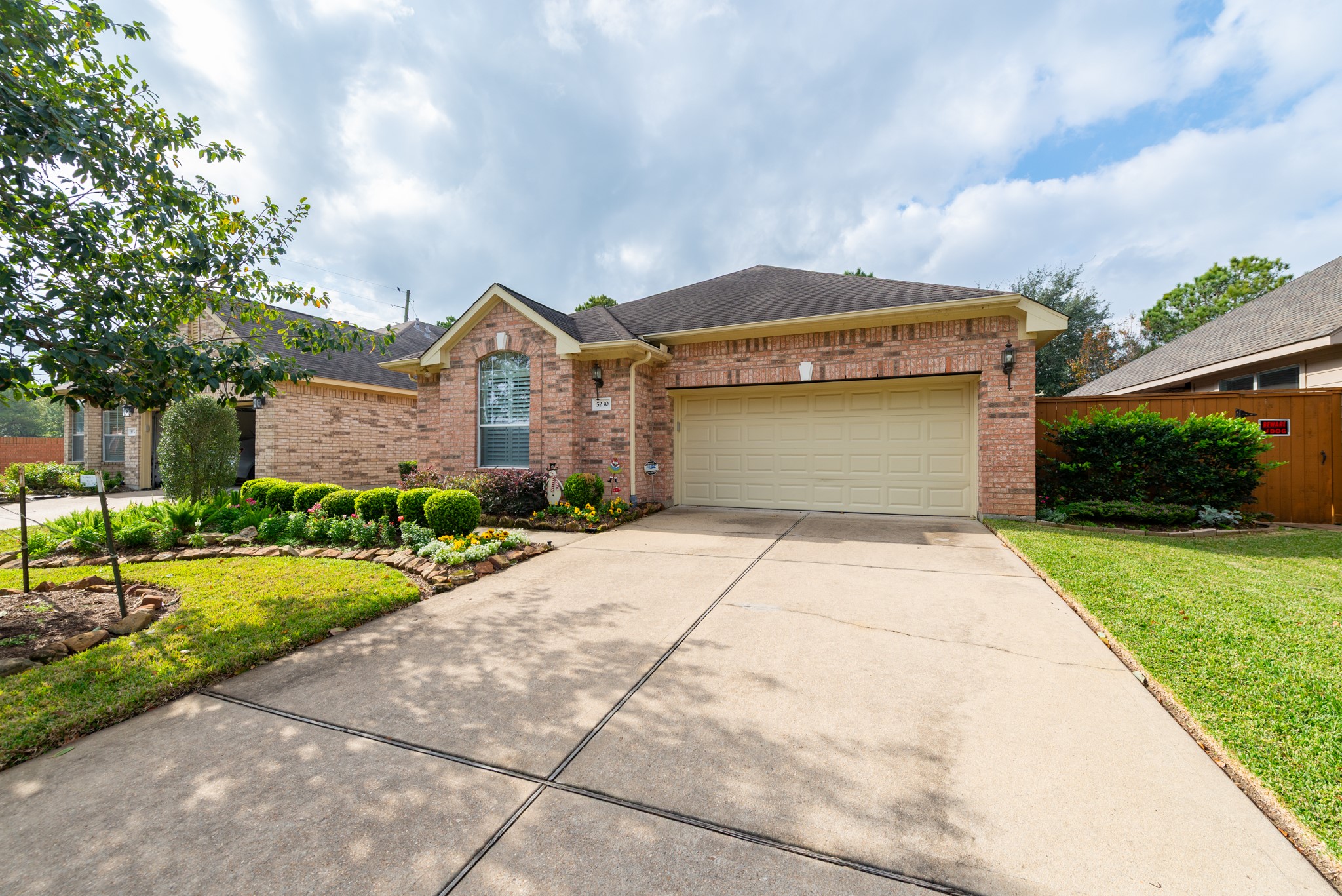 5230 Sandyfields Lane Katy, TX 77494 - Photo 2 of 24 Brick home with a wide driveway and two-car garage, featuring a whole-home water softener for added comfort and convenience.