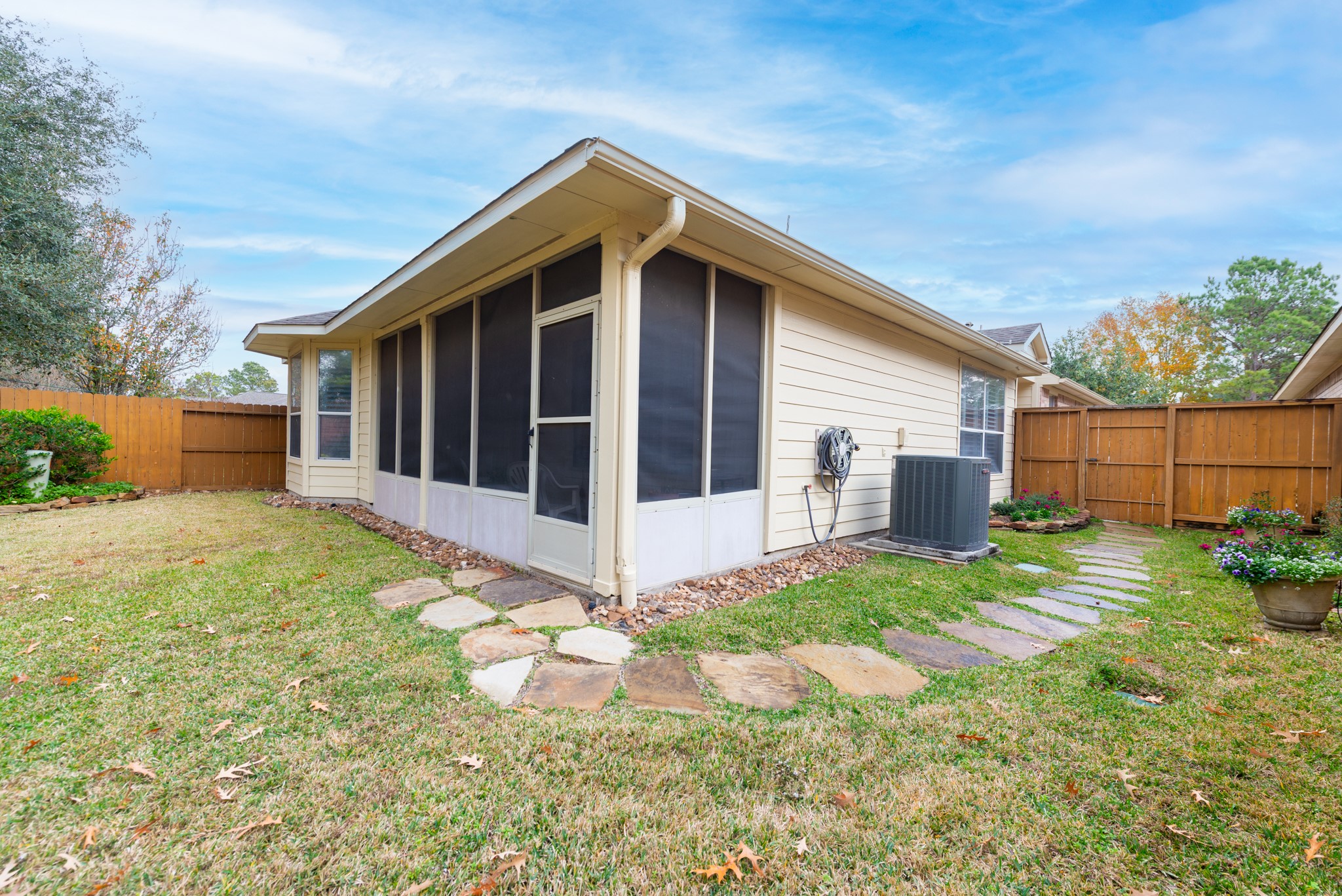 5230 Sandyfields Lane Katy, TX 77494 - Photo 23 of 24 Exterior view of the screened-in porch, offering a covered outdoor space with direct access to the backyard and adjacent lawn area.