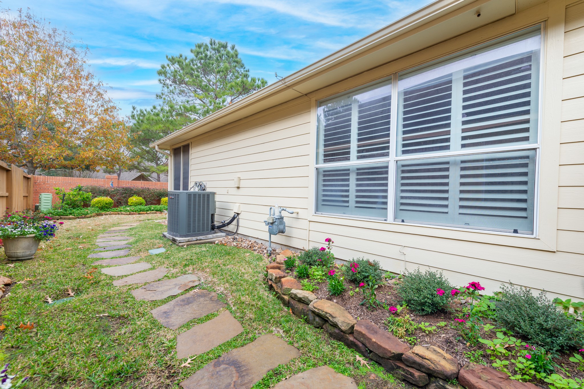 5230 Sandyfields Lane Katy, TX 77494 - Photo 24 of 24 Side yard with stone pathway, maintained lawn, and landscaped beds along the exterior of the home, providing easy access around the property.
