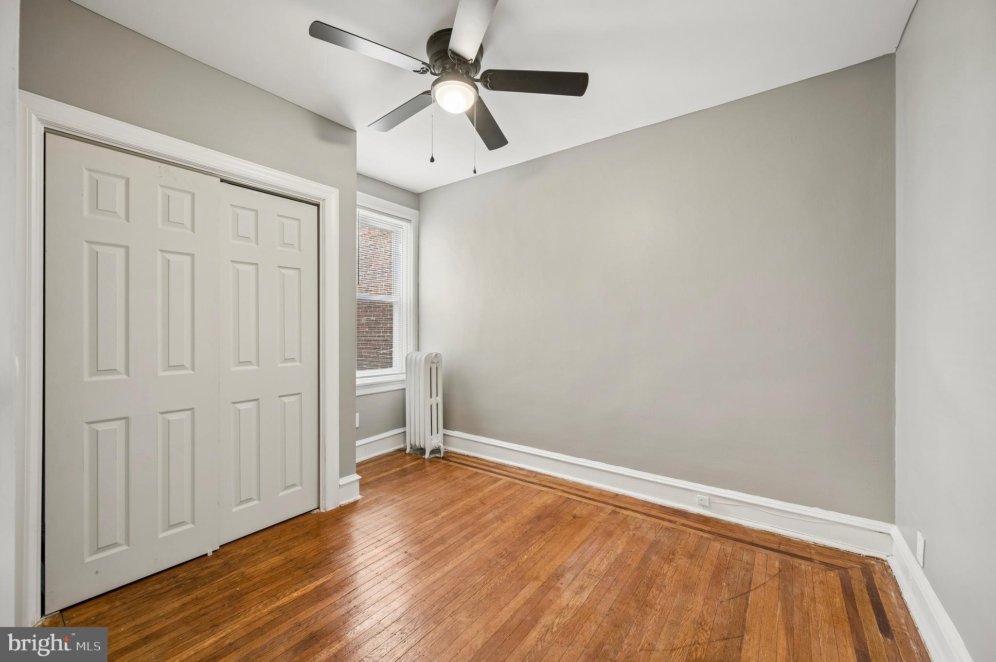 5625 Willows Avenue Philadelphia, PA 19143 - Photo 12 of 15 an empty room with wooden floor chandelier fan and windows
