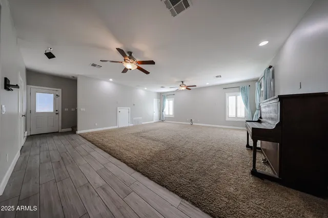 a view of a livingroom with a fireplace furniture and a ceiling fan