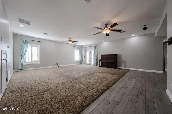 a view of a livingroom with a ceiling fan window and wooden floor