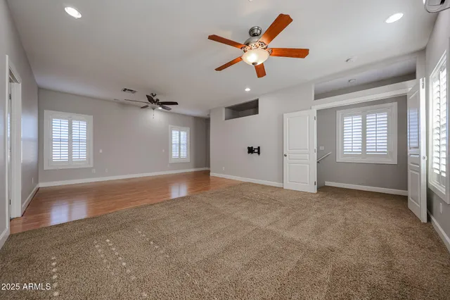 an empty room with windows and fan