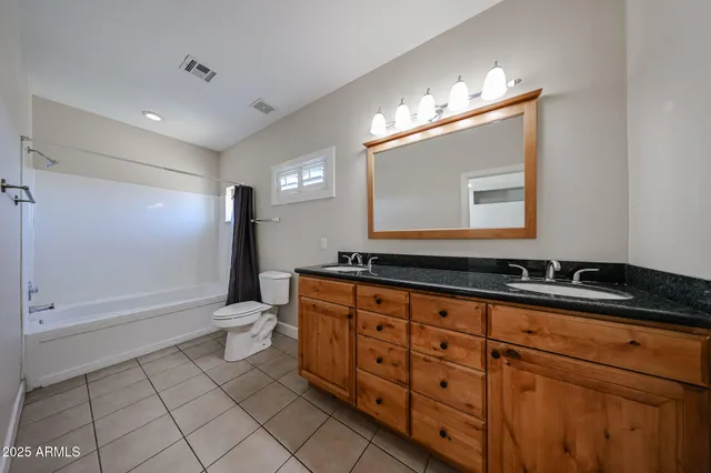 a bathroom with a sink a toilet a mirror and shower