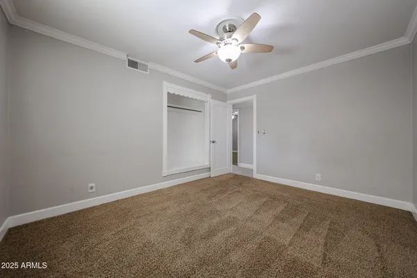 a view of an empty room with a chandelier fan