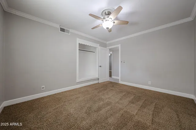 a view of an empty room with a chandelier fan