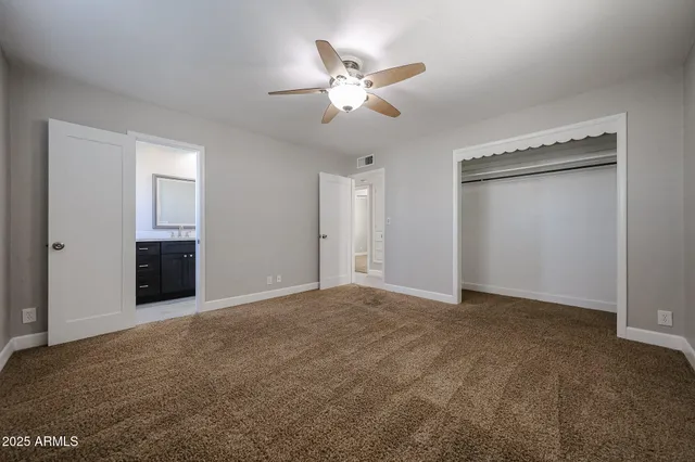 a view of an empty room with a ceiling fan