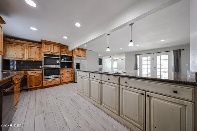 a large kitchen with stainless steel appliances and a large window