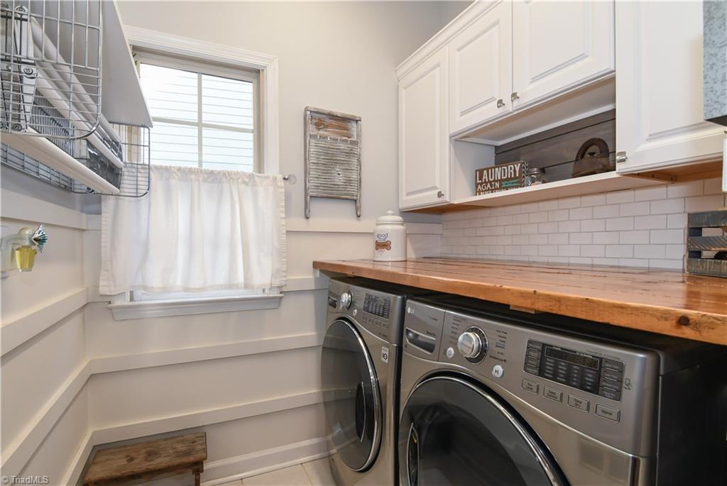 6401 High View Road Greensboro, NC 27410 - Photo 13 of 28 Even the laundry room is fantastic! Cabinets for storage, subway tile back splash, tile floors, counter space for storage or folding laundry and a built in drying rack!