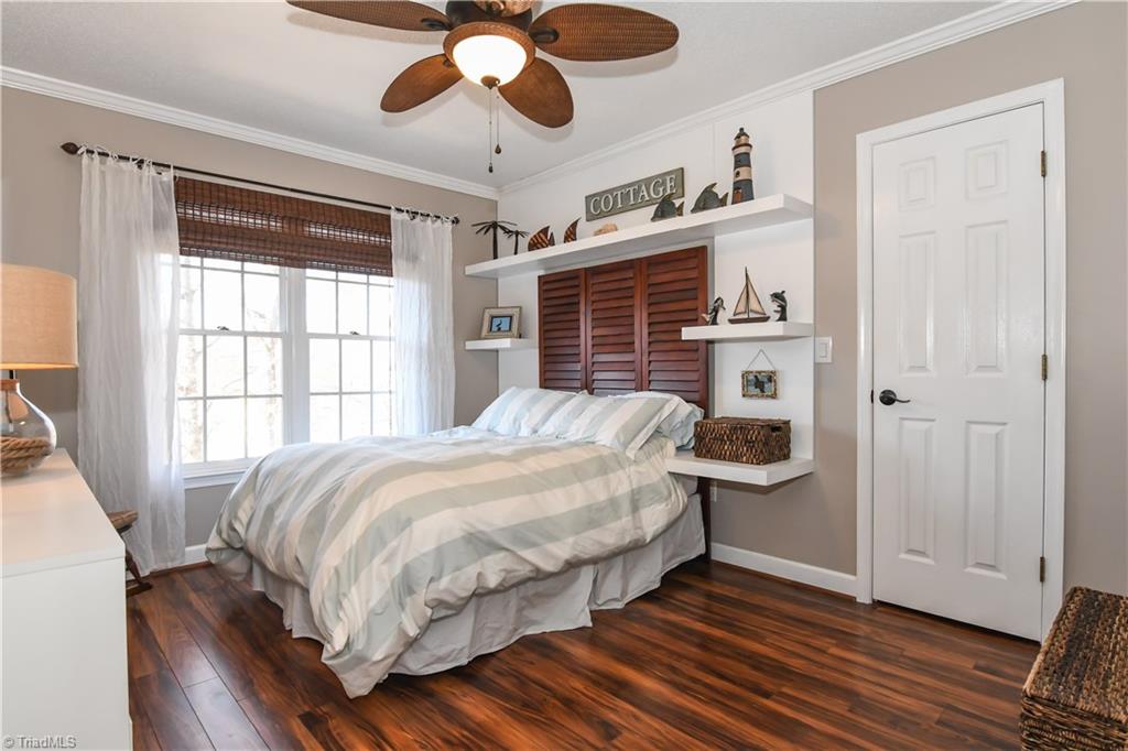6401 High View Road Greensboro, NC 27410 - Photo 21 of 28 4th bedroom features laminate hardwood flooring, neutral paint, crown molding and a ceiling fan!