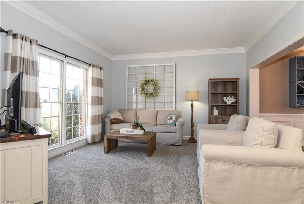 6401 High View Road Greensboro, NC 27410 - Photo 5 of 28 Living Room features brand new carpet, floor to ceiling windows for lots of natural light, crown molding and soft, inviting paint.