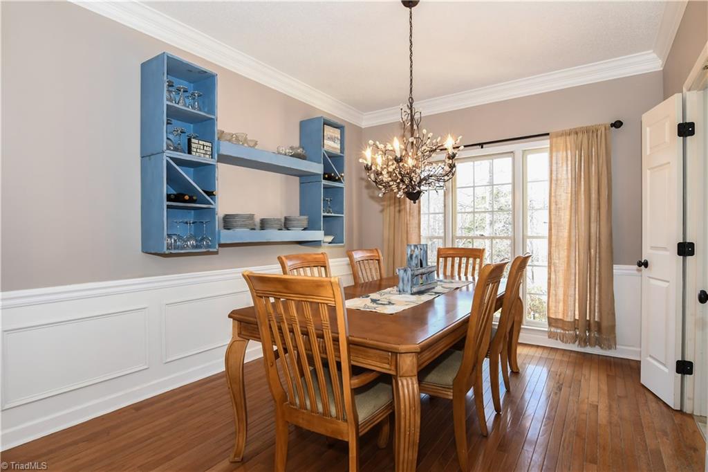 6401 High View Road Greensboro, NC 27410 - Photo 6 of 28 Dining Room features hardwood floors, chair railing, crown molding, a gorgeous light fixture and open wall shelving to showcase your fabulous dinnerware!