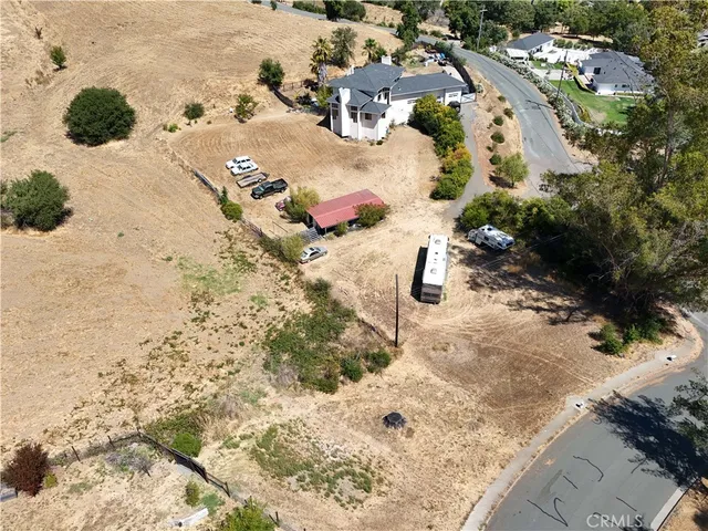 a view of a dry yard with wooden fence