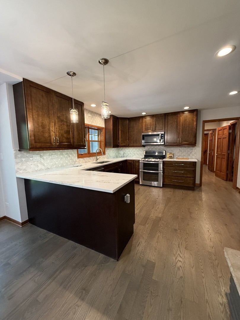2841 Orange Brace Road Deerfield, IL 60015 - Photo 3 of 30 a large kitchen with stainless steel appliances kitchen island granite countertop a stove and a sink