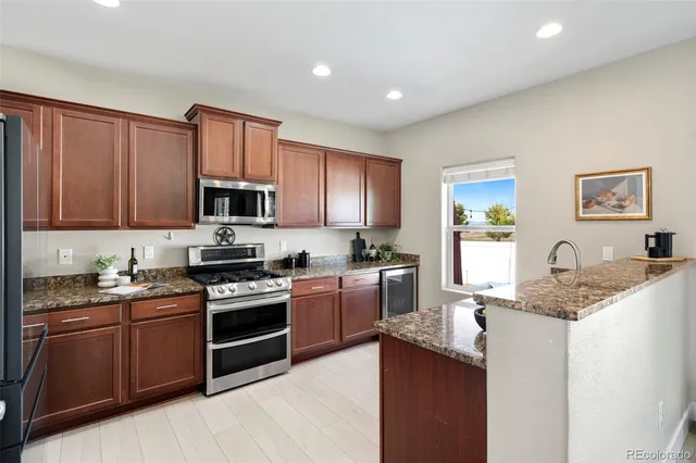 a kitchen with stainless steel appliances granite countertop a sink stove microwave and cabinets