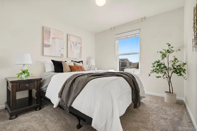a bedroom with bed and a potted plant